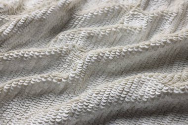 Arkaplan olarak beyaz payetli güzel kumaş, yakın görünüm