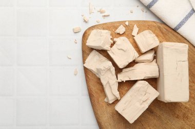 Beyaz fayanslı masada taze maya parçaları, üst manzara. Metin için boşluk