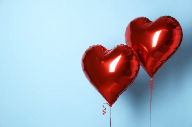 Açık mavi arka planda kalp şeklinde kırmızı balonlar, yazı için boşluk. Sevgililer Günü
