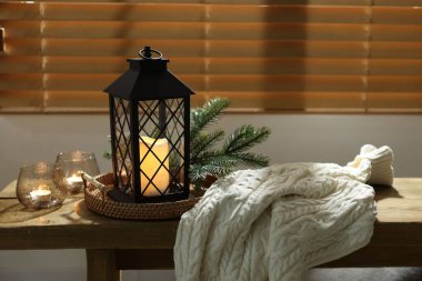 Noel feneri, yanan mumlar ve kapalı bir bankta kazak. Sıcak atmosfer