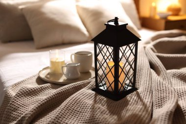 Güzel bir Noel feneri, yanan mumlar ve sıcak bir bardak içecekle birlikte.