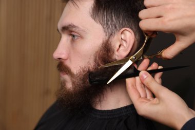 Berber dükkanında adamın sakalını buduyor, yakın plan.