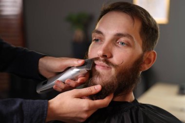 Berber dükkanında adamın bıyığını buduyor, yakın plan