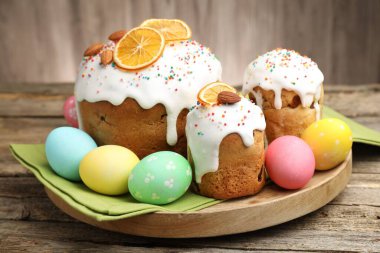 Nefis dekore edilmiş Paskalya pastaları ve yumurtalar ahşap masada, yakın plan.