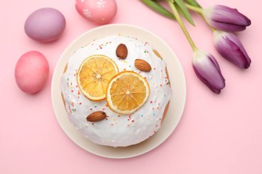 Güzel Paskalya pastası, pembe arka planda yumurtalar ve laleler, düzlük