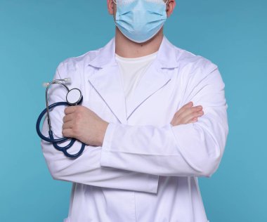 Açık mavi arka planda steteskobu olan doktor, yakın plan.