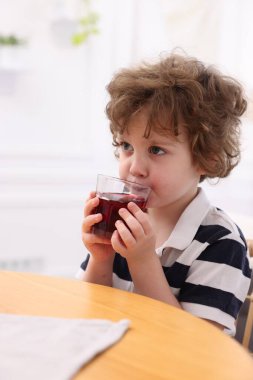 Küçük çocuk içeride taze nar suyu içiyor.