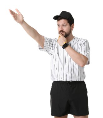 Üniformalı hakem beyaz arka planda düdük çalıyor.