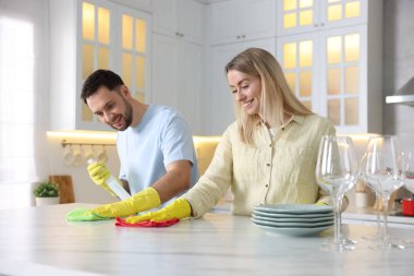 Mutfakta beyaz mermer masayı temizleyen çift.