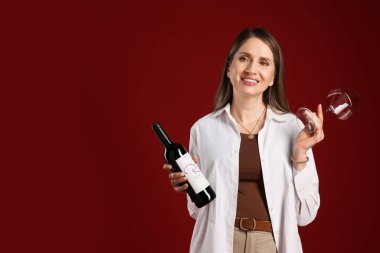 Kırmızı arka planda cam ve şarap şişesi olan profesyonel şarap garsonu. Metin için boşluk