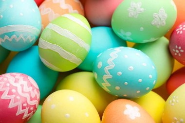 Many painted Easter eggs on yellow background, flat lay