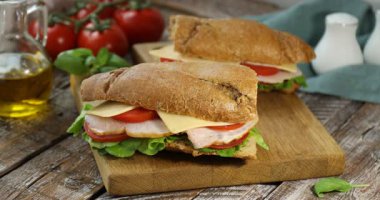 Ahşap masaya fesleğenli ekmekli sandviç koyan kadın, yakın plan.