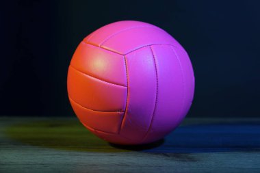 Yerde bir voleybol topu koyu arkaplana karşı, yakın plan.