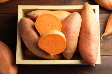 Tahta masadaki sandıkta çiğ patates.