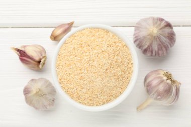 Kavanozda kurutulmuş sarımsak ve beyaz ahşap masada taze sebzeler.