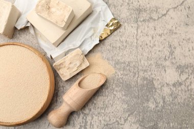 Taze, kurutulmuş maya parçaları, gri desenli masada kepçe ve kase, düz yatış. Metin için boşluk