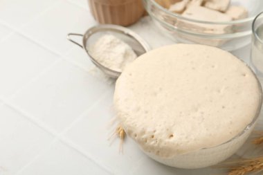 Cam kasede taze maya hamuru ve beyaz fayanslı masada malzemeler, yakın plan. Metin için boşluk