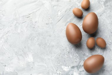 Paskalya kutlaması. Gri desenli masa üzerinde bir sürü çikolata yumurtası, düz ve metin için yeri var.