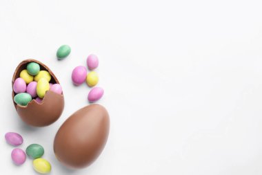 Beyaz arka planda çikolatalı Paskalya yumurtaları ve şekerler. Metin için boşluk