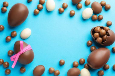 Açık mavi arkaplanlı çikolatalı Paskalya yumurtaları. Metin için boşluk