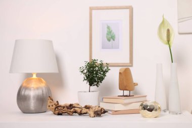 Beyaz duvarın yanında güzel vazolar ve diğer dekorlar.