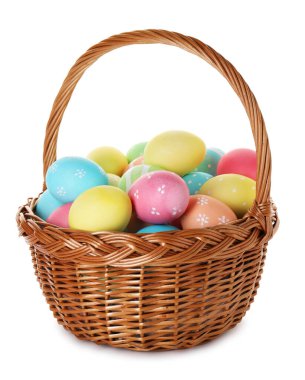 Hasır sepetteki boyanmış Paskalya yumurtaları beyaza izole edilmiş.