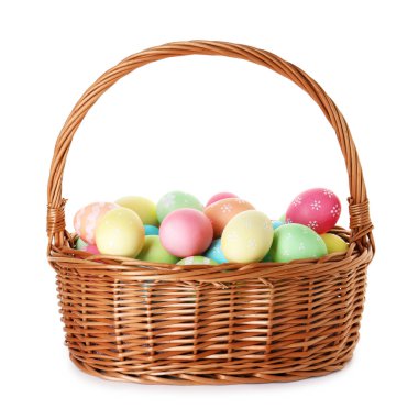 Hasır sepetteki boyanmış Paskalya yumurtaları beyaza izole edilmiş.