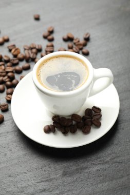 Kahveyi fincanda, fasulyeyi koyu dokulu masada tazeliyorum.