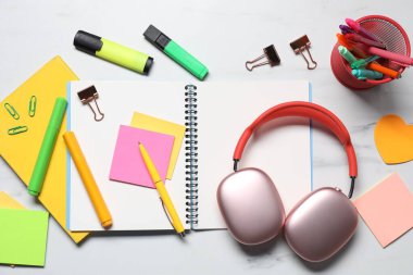 Kulaklıklar ve kırtasiye malzemeleri beyaz mermer masa, düz yatıyordu.