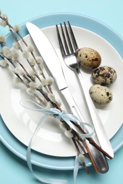 Paskalya kutlaması. Açık mavi arka planda söğüt dalları ve bıldırcın yumurtalarıyla şenlik masası.