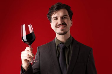 Kırmızı arka planda şarap kadehi olan profesyonel şarap garsonu.