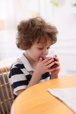 Küçük çocuk içeride taze nar suyu içiyor.