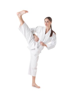 Üniformalı kadın beyaz arka planda karate yapıyor.