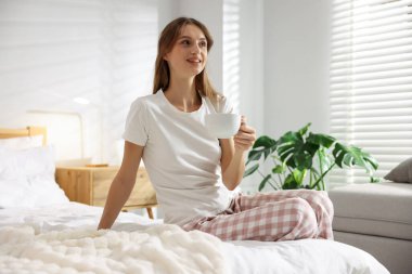 Evde yatağında bir fincan aromatik kahveyle güzel bir kadın. Metin için boşluk