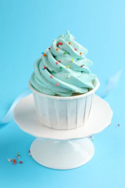 Açık mavi arka planda serpiştirilmiş lezzetli kek, yakın plan.