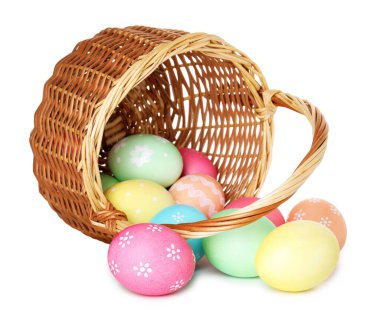 Mutlu Paskalyalar. Beyaza izole edilmiş boyanmış yumurtalarla çevrilmiş hasır sepet.