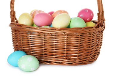 Hasır sepetteki boyanmış Paskalya yumurtaları beyaza izole edilmiş.
