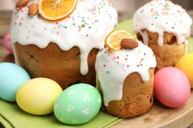 Nefis dekore edilmiş Paskalya pastaları ve yumurtalar ahşap masada, yakın plan.