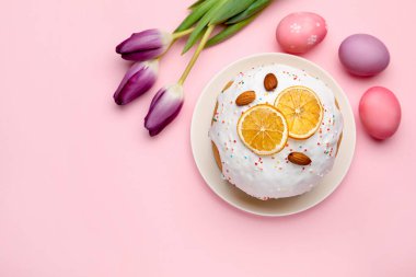 Güzel Paskalya pastası, pembe arka planda yumurtalar ve laleler, düz yatak. Metin için boşluk