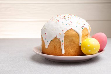 Açık gri masada güzel Paskalya pastası ve yumurtalar. Metin için boşluk