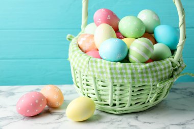 Güzel Paskalya yumurtaları beyaz mermer masada mavi ahşap arka planda, yakın plan