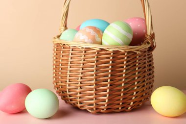 Güzel Paskalya yumurtaları pembe ahşap masada bej arka planda, yakın plan