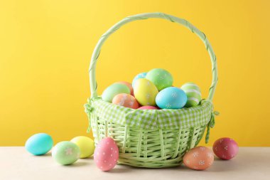 Güzel Paskalya yumurtaları beyaz masada, sarı arka planda.