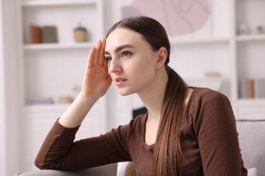 Hafıza kaybı. Evdeki koltukta bir şey hatırlamaya çalışan bir kadın.