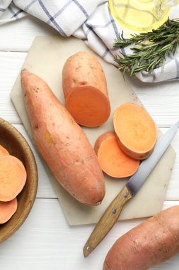 Çiğ patates, bıçak ve biberiye beyaz ahşap masa, düz yatıyordu.