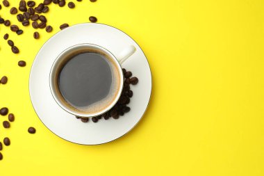 Kahveyi fincanda tazelemek ve sarı arka planda fasulye, düz uzanmak. Metin için boşluk