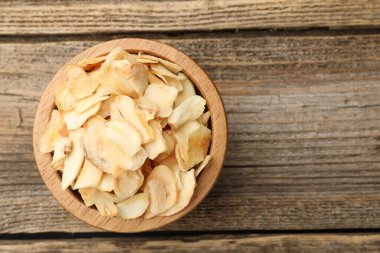 Tahta masadaki kasede kurutulmuş sarımsak taneleri, üst manzara. Metin için boşluk