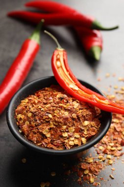 Kırmızı biber ve tanecikler gri masada, yakın plan.