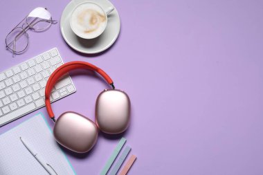Kulaklıklar, akıllı telefon, bilgisayar klavyesi, mor arka planda kahve ve kırtasiye malzemesi, düz konum. Metin için boşluk