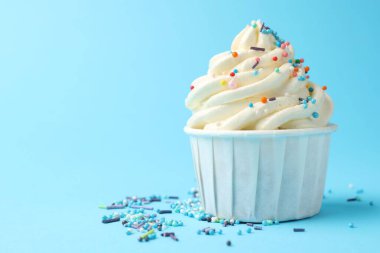 Açık mavi arka planda serpiştirilmiş lezzetli kek, yakın plan. Metin için boşluk